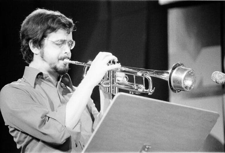 Black and white photo of Kenny Wheeler playing trumpet.