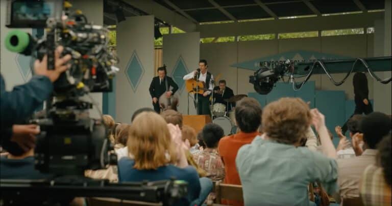 The set of A Complete Unknown, where Johnny Cash's band plays on stage to a crowd. The movie cameras are visible in the foreground.