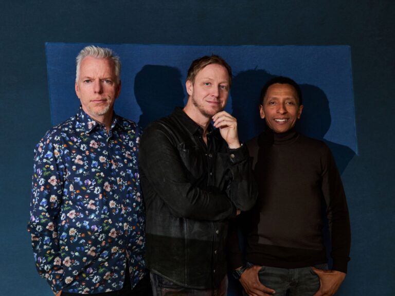 Jürgen Spiegel, Martin Tingvall and Omar Rodriguez Calvo standing together looking at the camera with a blue background