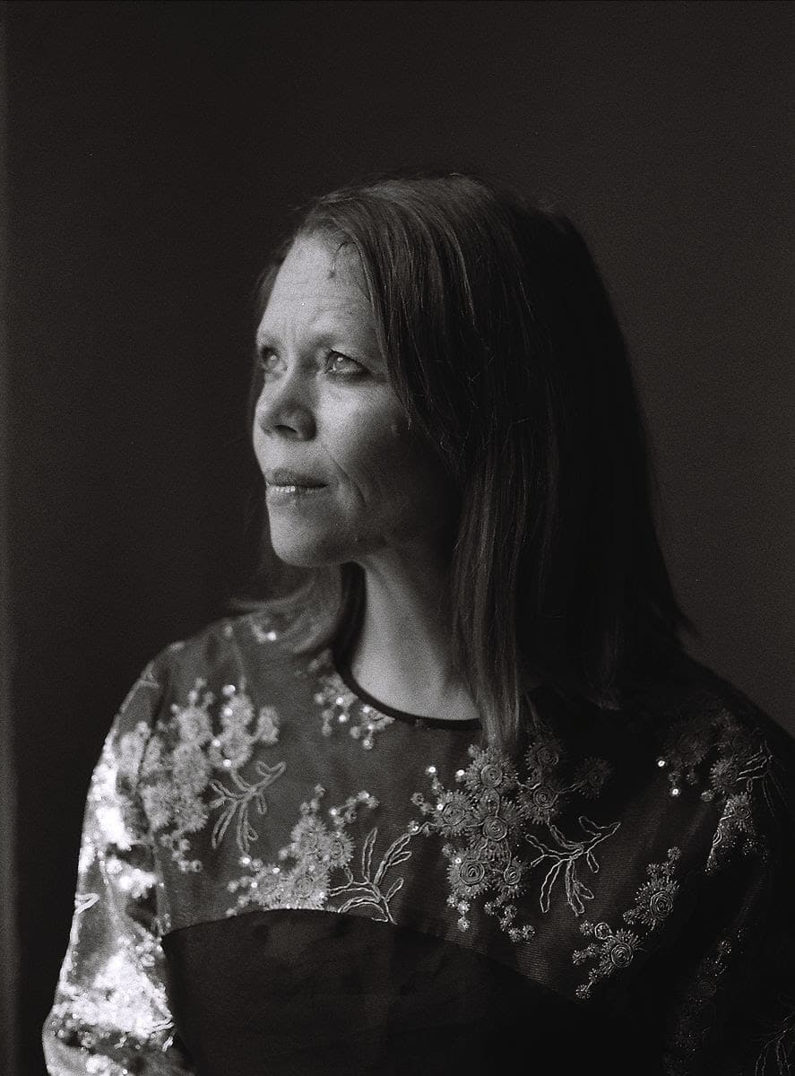 Black and white portrait of Caroline Davis. She is seated at an angle to the camera, looking into the distance.